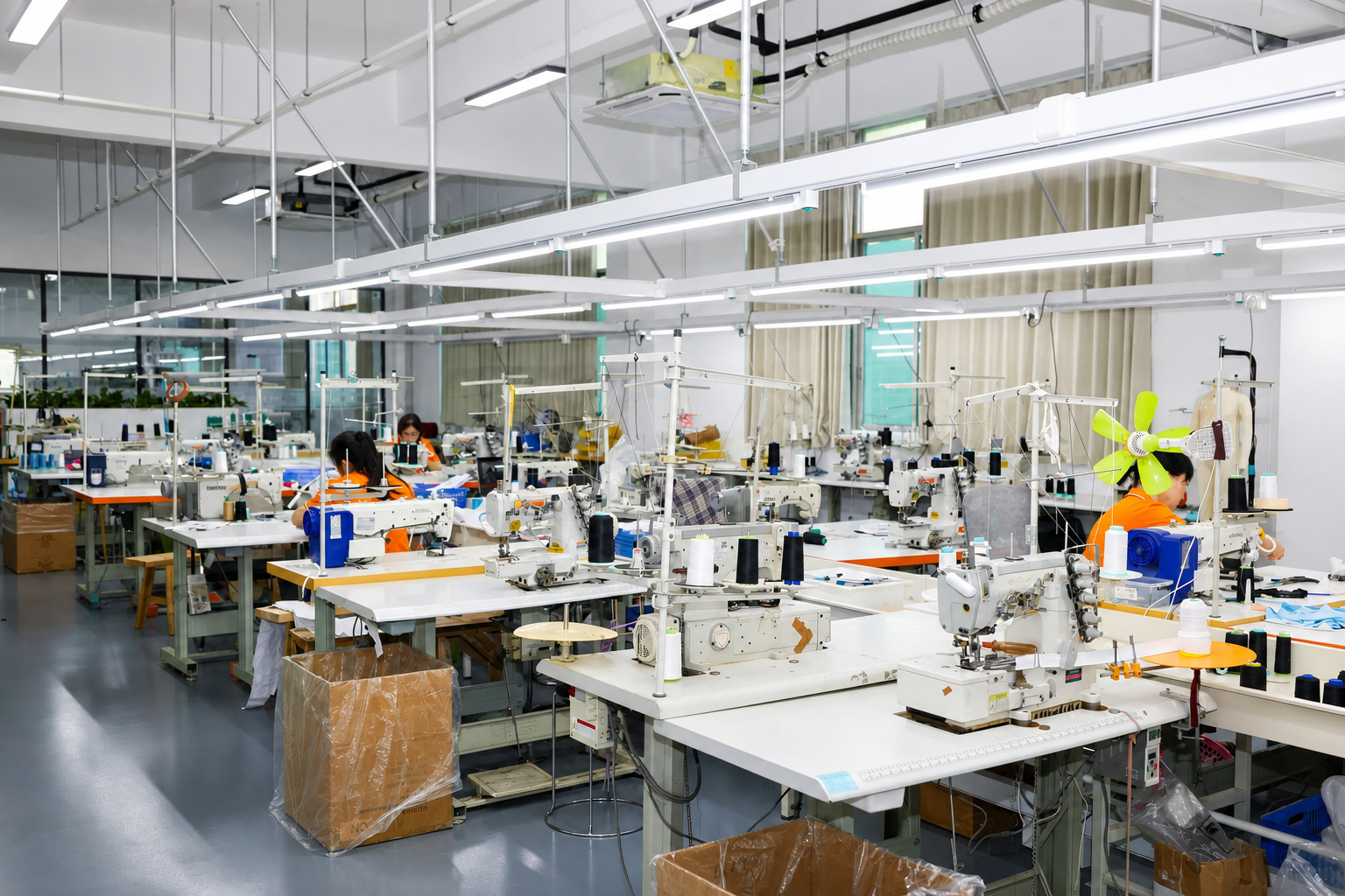 Workers operating industrial sewing machines in a general textile sewing area